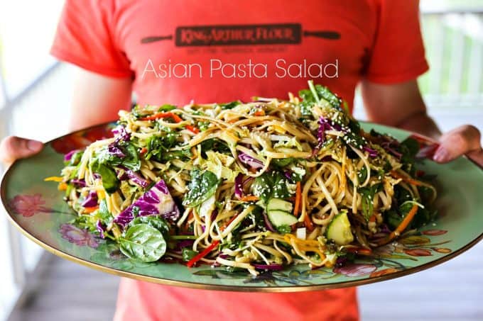 Asian noodle Salad with a garlic soy vinaigrette and loads of colourful, fresh vegetables on a Mackenzie Childs Platter held by a muscular teen boy.