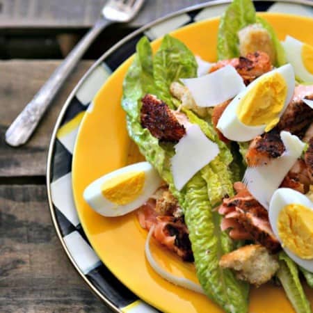 Simple, fresh, and filling main dish salad for spring! Blackened Salmon Caesar Salad with torn croutons, hard boiled egg, homemade dressing, and flaked blackened salmon gives the traditional Caesar salad a flavourful facelift!