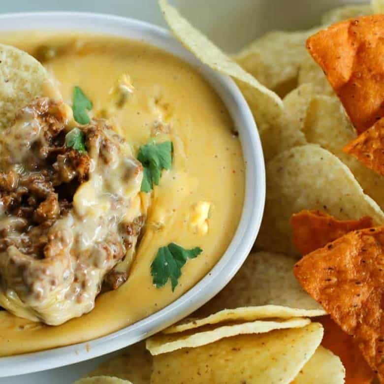 Ooey-gooey, chile studded heavenly queso smothers your favourite chili for a bowl of the ultimate Chili Con Queso Dip. Get those chips ready to go!