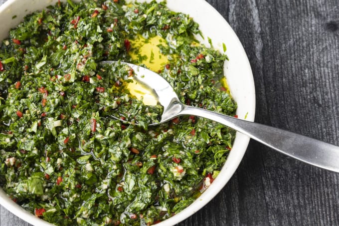 This Argentinian style chimichurri sauce recipe is one of the most versatile and flavourful sauces around. Traditionally served with grilled steak and sausages, this fresh herb and garlic sauce is also incredible with chicken, fish, vegetables, meatballs, potatoes, and so much more!