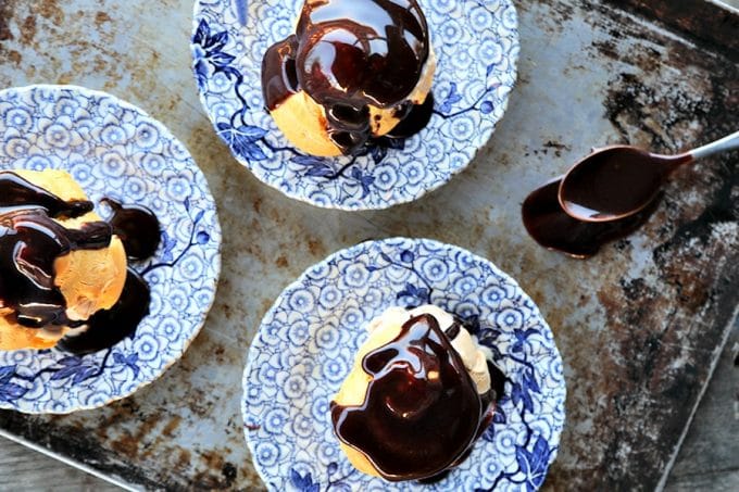 Homemade Cream Puffs filled with ice cream and topped with hot fudge sauce for profiteroles, plus a bonus tip on how to freeze choux pastry ahead of time for almost instant cream puffs!