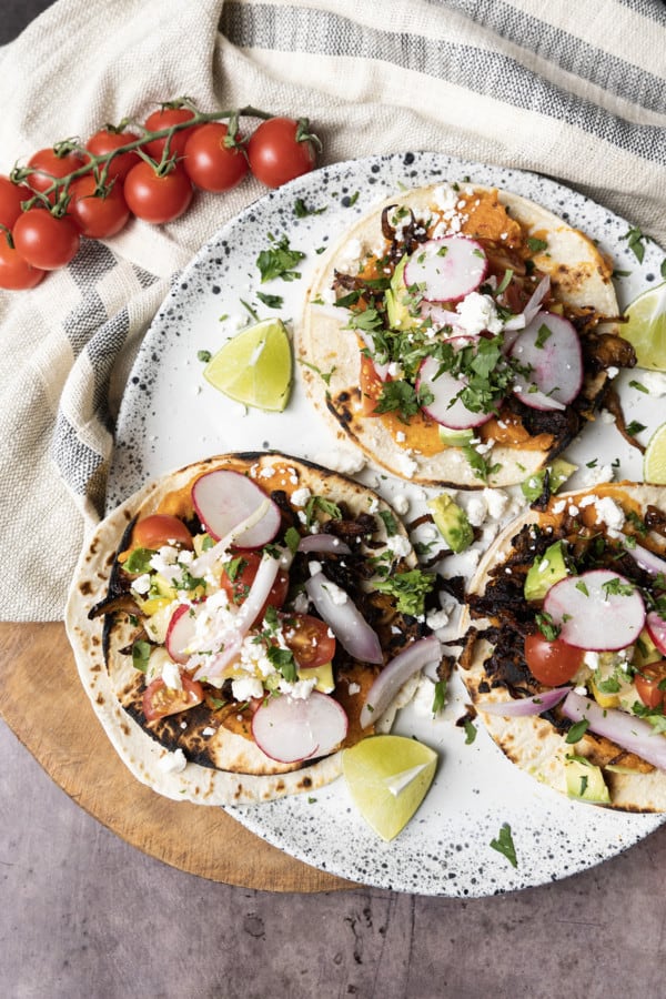 This crispy mushroom taco recipe with the works is for all my obsessive mushroom loving friends. It’s unapologetically mushroom forward, so this is not for you if you’re not into fungi. It’s almost laughably easy to make this substantial meatless taco recipe. Roasting the seasoned mushrooms on a metal sheet pan in a hot oven gives them delectable crispy edges.