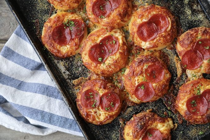 Pepperoni Pizza Bialys Recipe: fresh-from-the-oven, chewy, bagel-like bread topped with chopped garlic, the barest hint of pizza sauce and olive oil, a generous cap of melted cheese, and a couple of crispy-edged pepperoni to crown it.