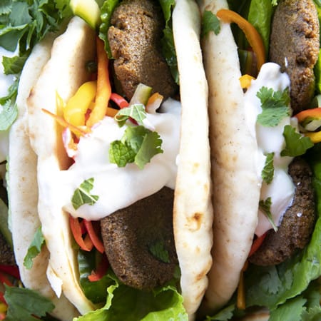 Falafel in flat bread with yogurt, pickled vegetables, lettuce, and cilantro.