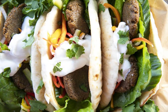 Falafel in flat bread with yogurt, pickled vegetables, lettuce, and cilantro.