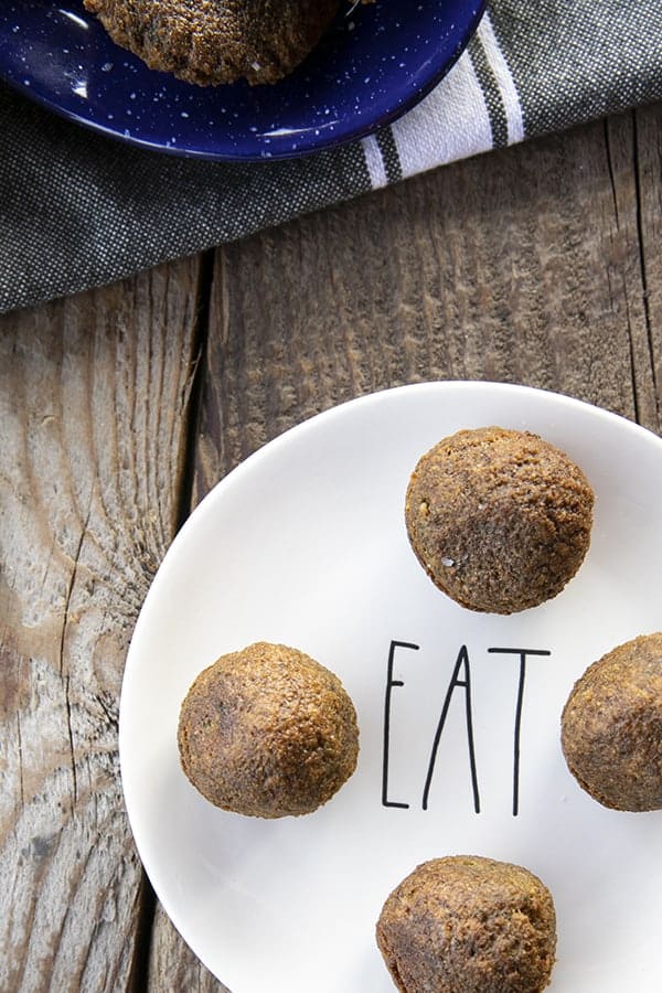 falafel balls on a plate that says "eat" and a wooden table