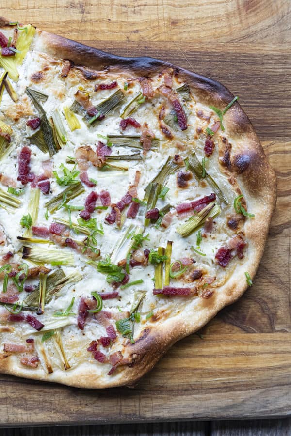 Flammekueche, tarte Flambée, or flammkuchen is a fast and easy bacon and onion pizza type flatbread made with crème fraîche or sour cream. No yeast needed!