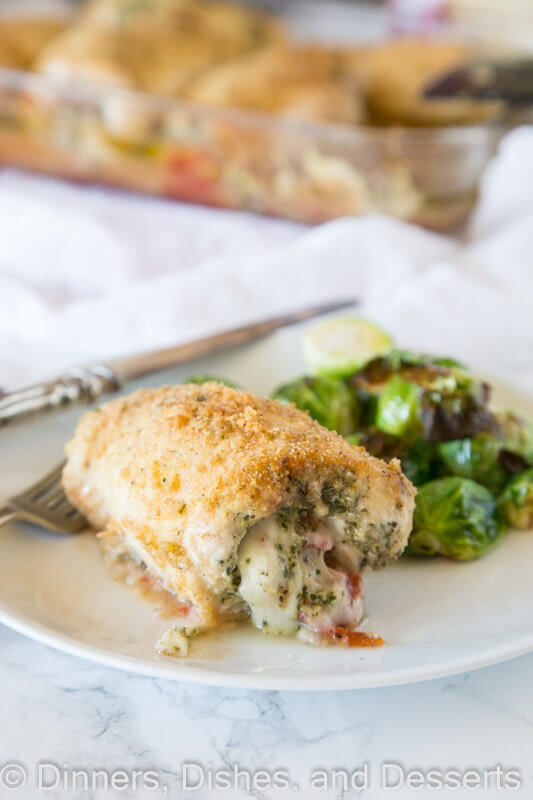 Italian Stuffed Chicken - chicken breasts rolled up with pesto, tomatoes, and cheese! Then baked until crispy and delicious, a great family dinner.