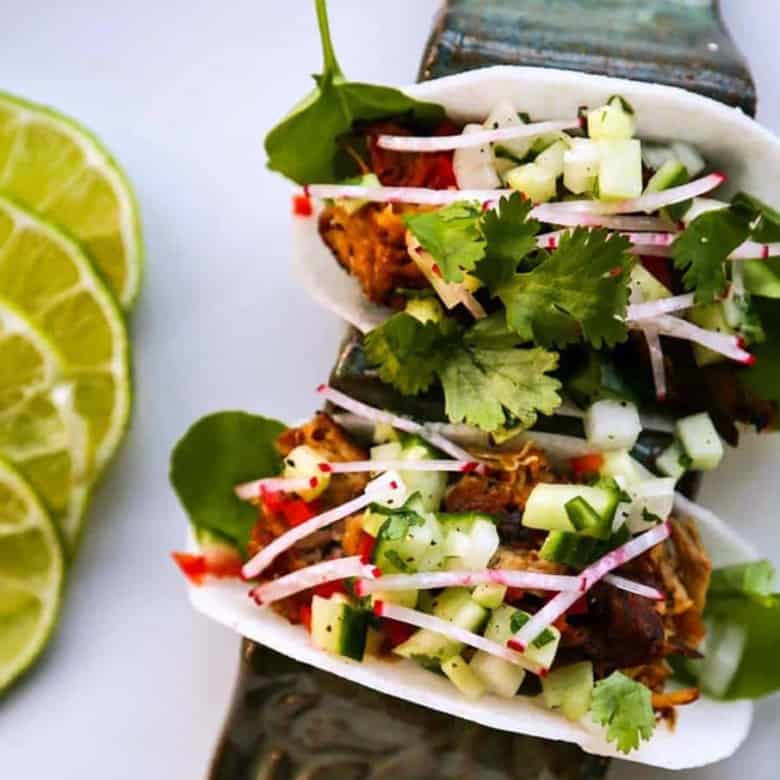 Jicama Tacos with carnitas, cucumber onion salsa, radishes, and cilantro.