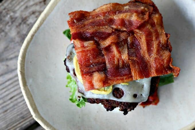 This Low-Carb Bacon Bun Swiss Burger is still seriously indulgent with a basket-weave bacon bun, melted Swiss cheese, a ground chuck burger, a hint of Dijon mustard, leaf lettuce, fresh tomato, and sweet onion. Hang onto that last bit of summer!