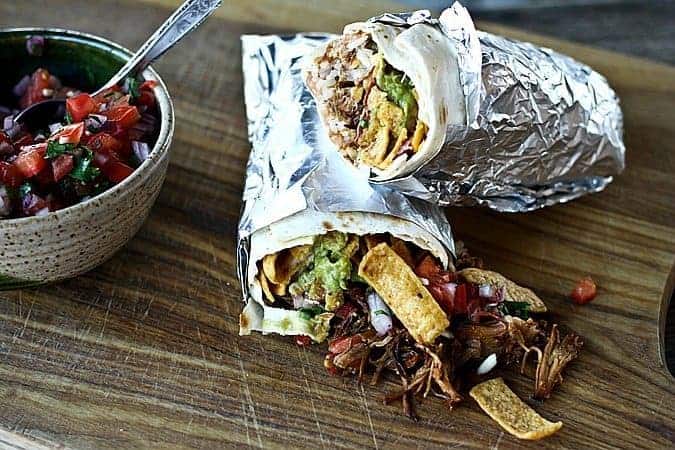 Neato Frito Overstuffed Burrito with pulled pork, guacamole, refried beans, rice, Fritos, cheese, Ranch dressing, and barbecue sauce.