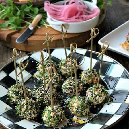 These gorgeous little two-bite, miniature cheese balls are dressed up with smoked salmon, chives, and everything bagel seasoning and taste like New York City when served with bagel chips, pickled red onions, and capers.