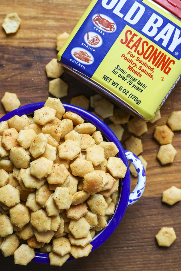 Old Bay Seasoned Oyster Crackers in a blue and white bowl with a canister of Old Bay Seasoning.