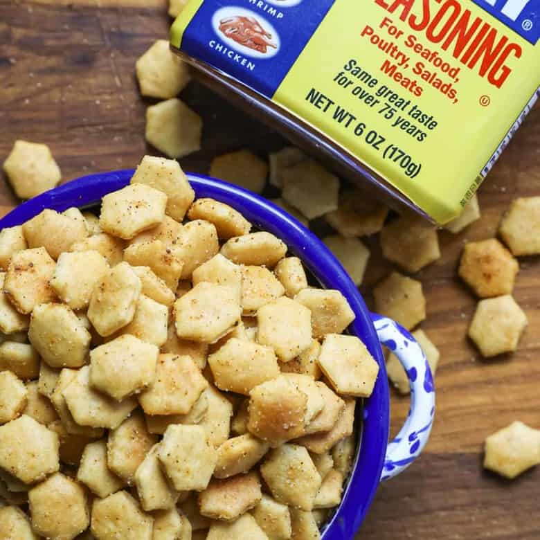 Old Bay Seasoned Oyster Crackers in a blue and white bowl with a canister of Old Bay Seasoning.