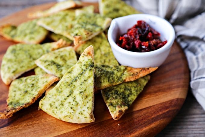 Crispy, crunchy, perfect pesto brushed homemade pita chips are as easy as cut, brush, bake and make a great snack or salad accompaniment.