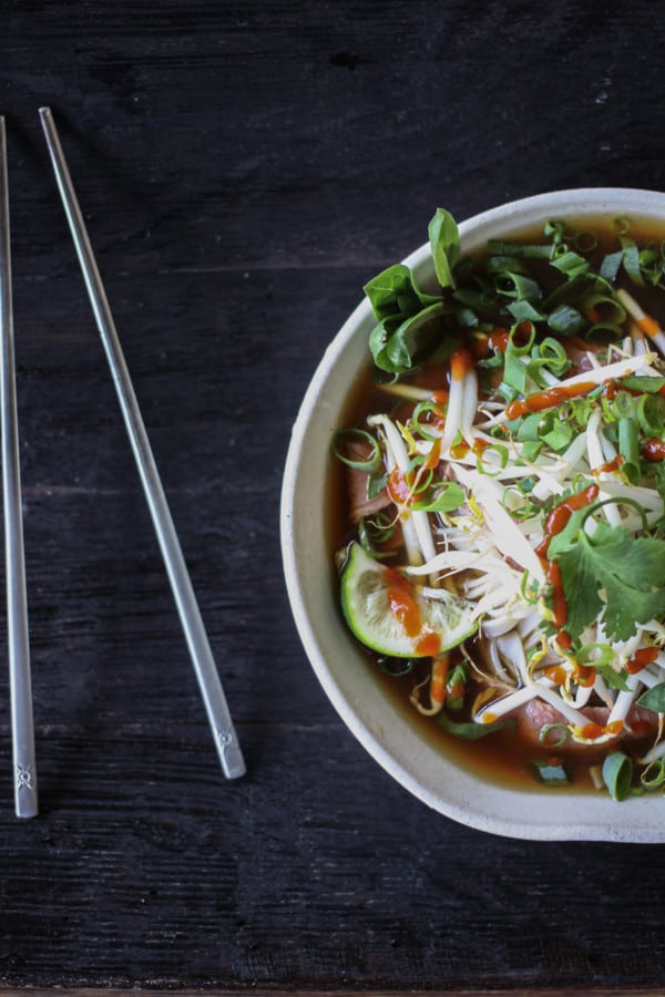 Easy Pho recipe: fragrant beef broth, slices of beef, rice noodles, sprouts, cilantro and basil, hot peppers, and a squeeze of lime!