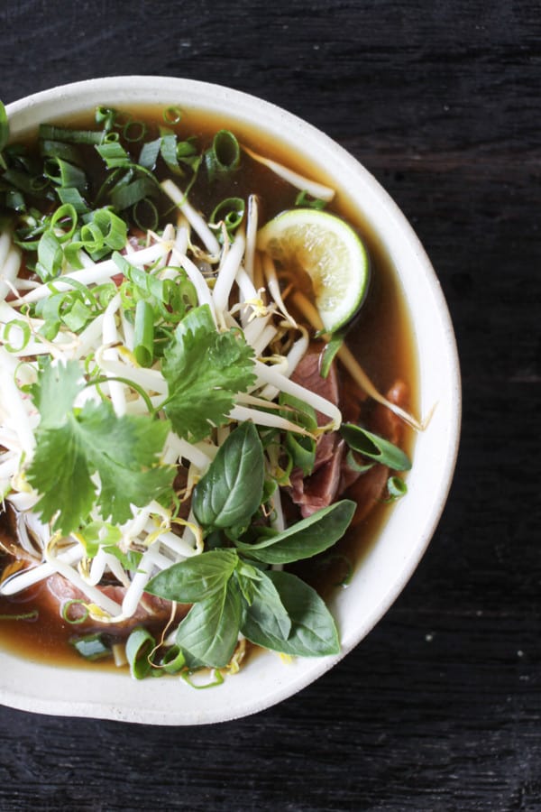 Easy Pho recipe: fragrant beef broth, slices of beef, rice noodles, sprouts, cilantro and basil, hot peppers, and a squeeze of lime!