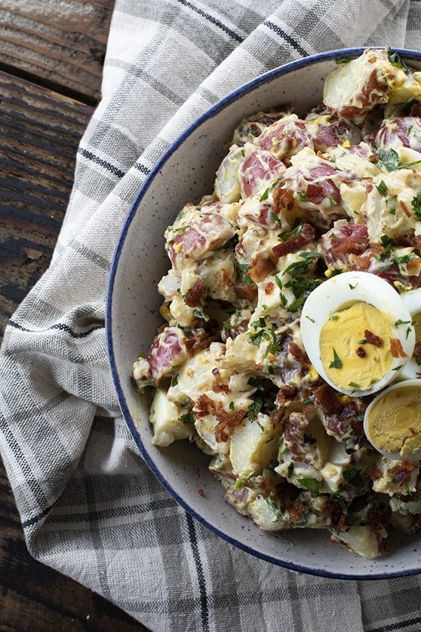 This next level potato salad has a full pound of crispy bacon, a creamy dressing with a hint of Dijon mustard, fresh herbs, hard boiled eggs, and tender potatoes. It's sure to be your new favourite potato salad for grilling and picnic season.