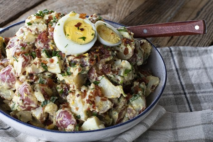 This next level potato salad has a full pound of crispy bacon, a creamy dressing with a hint of Dijon mustard, fresh herbs, hard boiled eggs, and tender potatoes. It's sure to be your new favourite potato salad for grilling and picnic season.