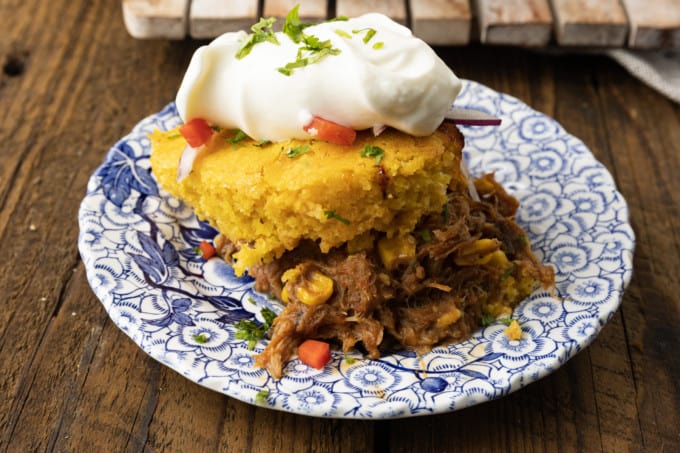 This satisfying, comforting Pulled Pork Casserole lets you get a dinner the whole family will love on the table even on busy weeknights. Saucy, succulent pulled pork with tender black beans and sweet corn is baked under golden brown cornbread in this easy casserole. Serve it alone or topped with all sorts of taco goodies like sour cream, grated cheese, onions, tomatoes, avocado, and taco sauce.