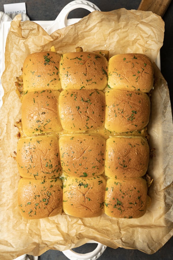 Easy Pulled Pork Sliders: Pillowy rolls filled with delicious, mouth-watering, tender pulled pork, bbq sauce, and cheese are brushed with melted butter, garlic, and herbs, then baked to toasty, melty perfection. They’re like the little black dress of the sandwich world and perfect for every occasion. Bonus: They're done in 30 minutes from start to finish!