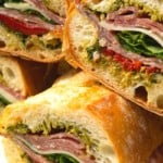 This is no ordinary Salami Sandwich; a crusty baguette is stuffed to bursting with a variety of salamis, roasted red pepper, pesto sauce, provolone cheese, fresh basil, and dressed arugula, then tightly wrapped and stashed in the refrigerator overnight. Then you can slice it all up and arrange it on a platter for a party or stretch it out for up to 5 days! And let me tell you, if you slice a little off of this every day for lunch with a cup of soup or bag of chips, you're going to feel very clever indeed. If you're feeling generous, pop it in a lunch bag for a school lunch that will make your kid the envy of the school.