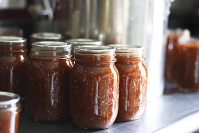 This Smoky Roasted Salsa is the little black dress of the salsa world; non-traditional, smoky, fine-textured, and slightly spicy with a bold flavour that’ll knock you out, this salsa is equally wonderful when dunked with chips, poured over meats in a slow-cooker, or spooned and baked on enchiladas. I have yet to find a commercially available salsa that matches this for depth, complexity, and utter fabulousness. I make this salsa in bulk -to the tune of a bushel each of tomatillos and plum tomatoes- every summer because the boys and their friends alike act neglected and depressed if we run out before summer rolls around. While it is far and away best when prepared in season, you can make it year ‘round in a salsa emergency. Believe me when I tell you if you run out, it will be a salsa emergency.