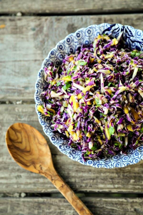 Spicy Mango Slaw is crunchy purple cabbage with a hint of tropical sweetness from just barely ripe mango, and the tart and tangy lime juice and honey dressing gets a flavour boost from minced red onion and fragrant cilantro.