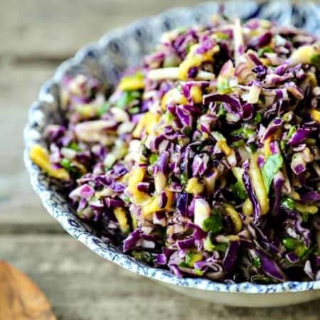 Spicy Mango Slaw is crunchy purple cabbage with a hint of tropical sweetness from just barely ripe mango, and the tart and tangy lime juice and honey dressing gets a flavour boost from minced red onion and fragrant cilantro.