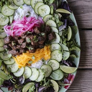 Bo Luc Lac -Shaking Beef- is a spectacularly fresh and flavourful Viêtnamese salad of mixed greens, cucumbers, pickled red onions, juicy mango, tender rice vermicelli noodles, bright herbs, and an irresistible black pepper lime dressing.